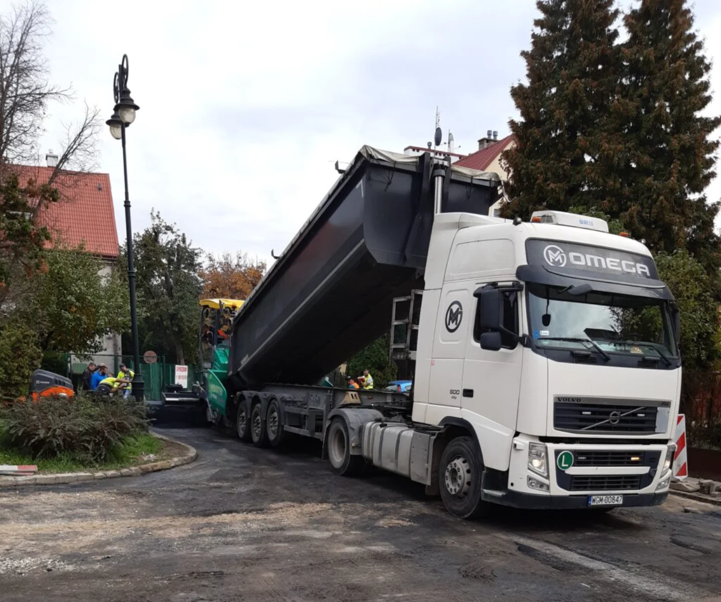 Wywrotka Omega z materiałem na ulicy podczas robót drogowych