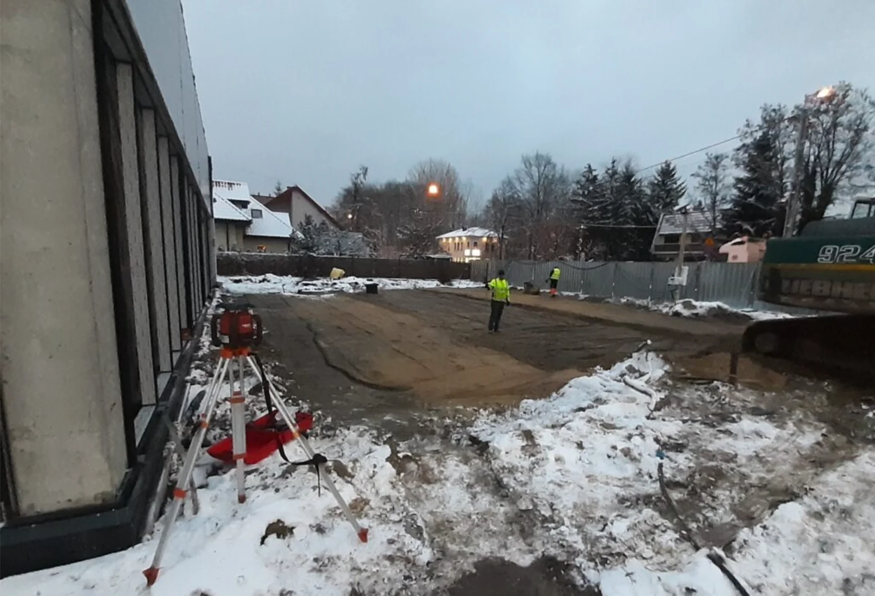 Wyrównany plac z niwelatorem zimą, prace ziemne na działce